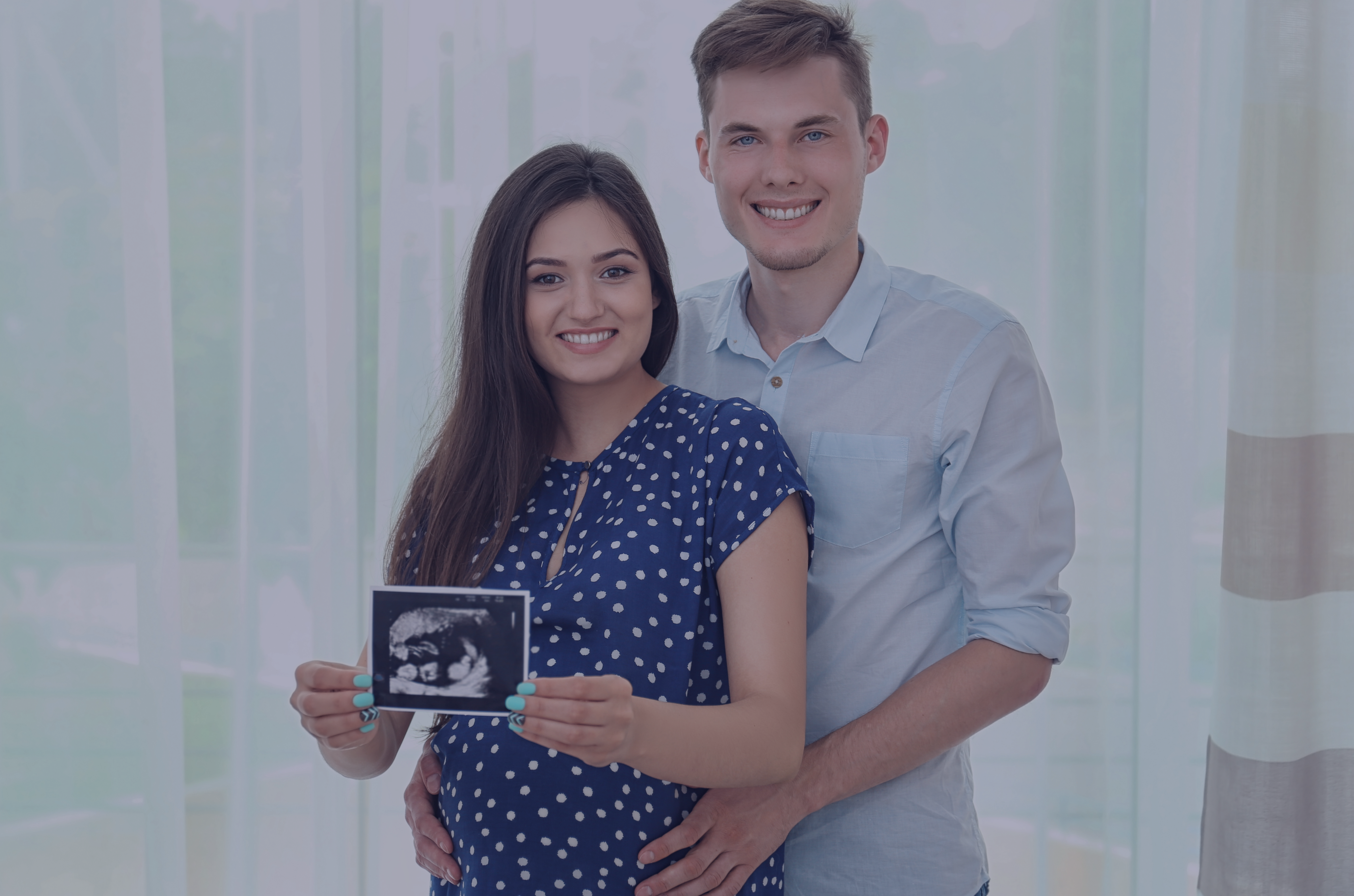 uśmiechnięta para w ciąży trzymająca zdjęcie usg