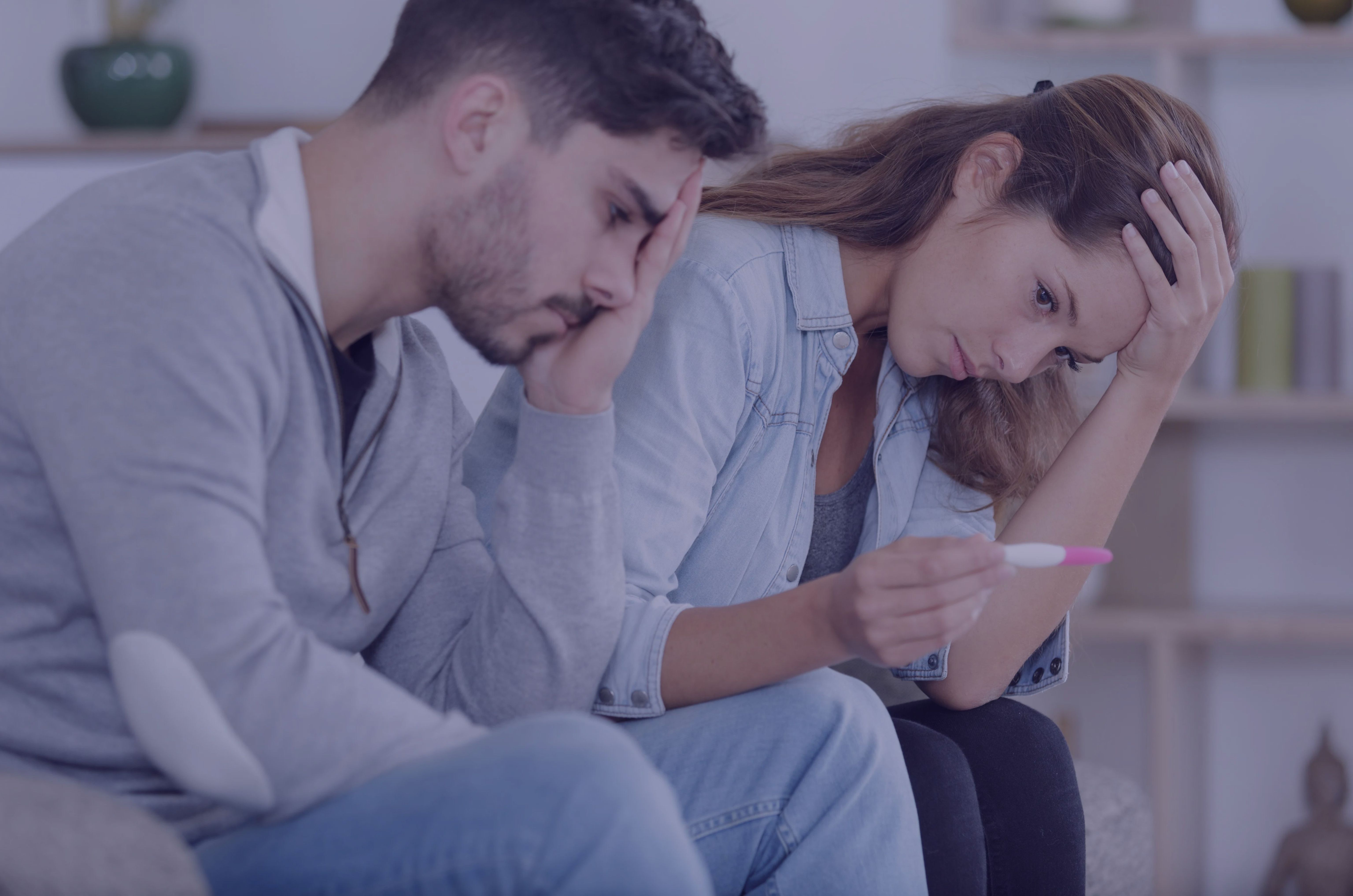 smutna para cierpiąca na niepłodność endokrynologiczną patrząca na negatywny test ciążowy