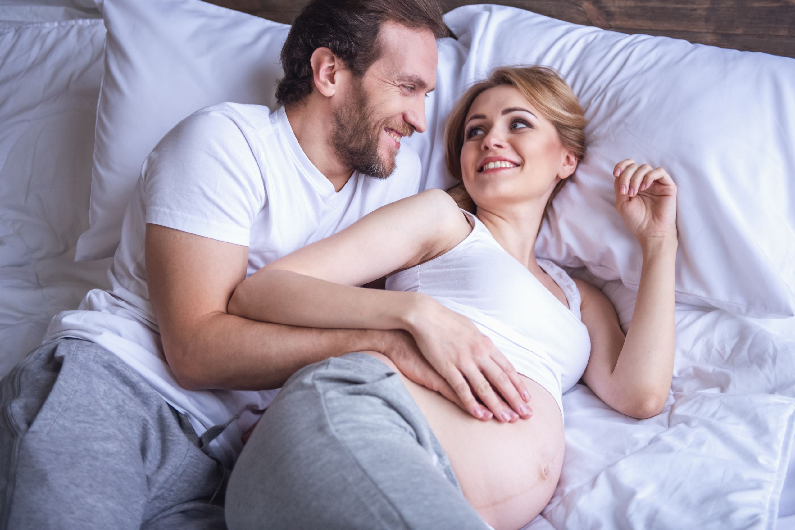 para w ciąży leżąca na łóżku