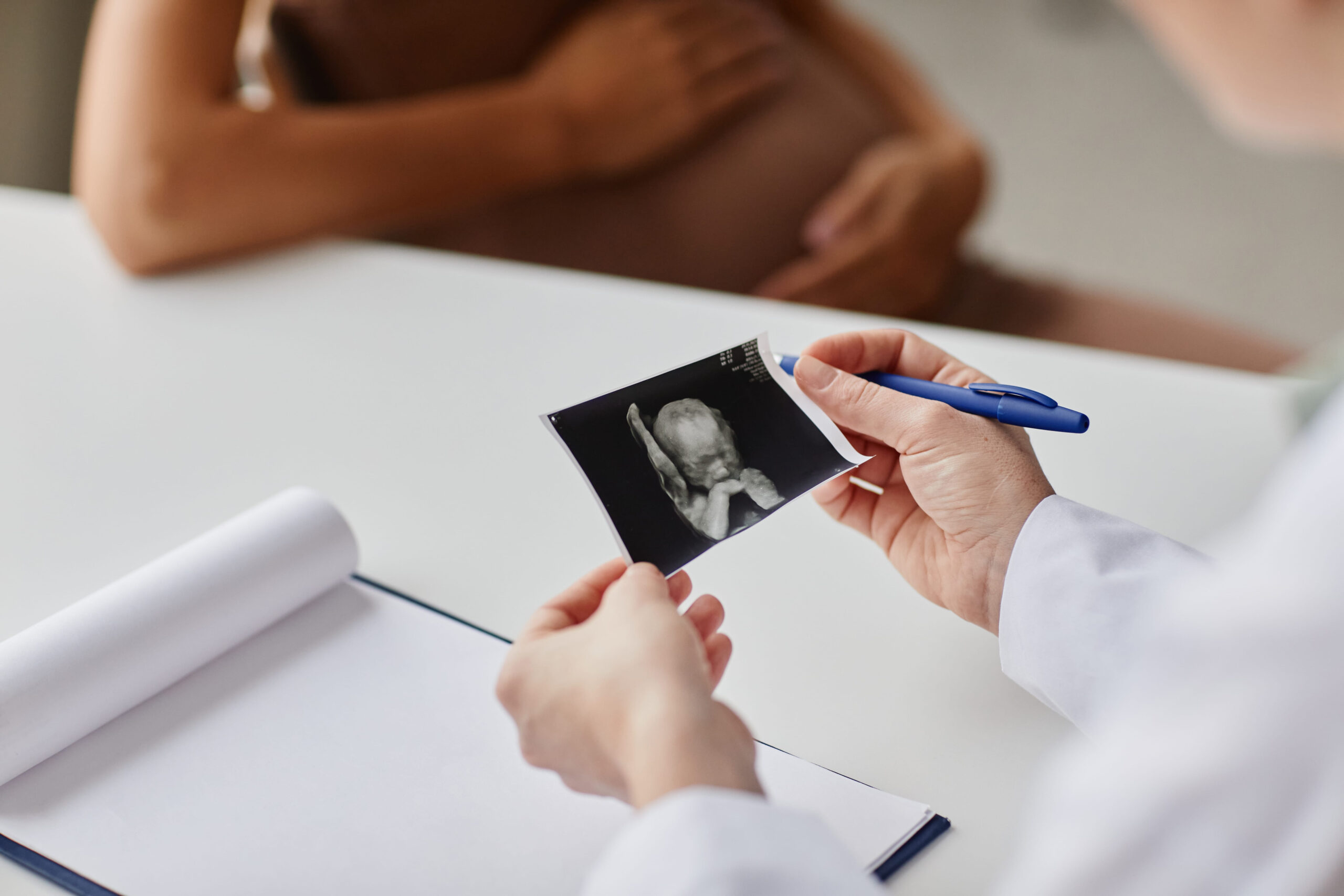 lekarz trzymający zdjęcie dziecka po USG